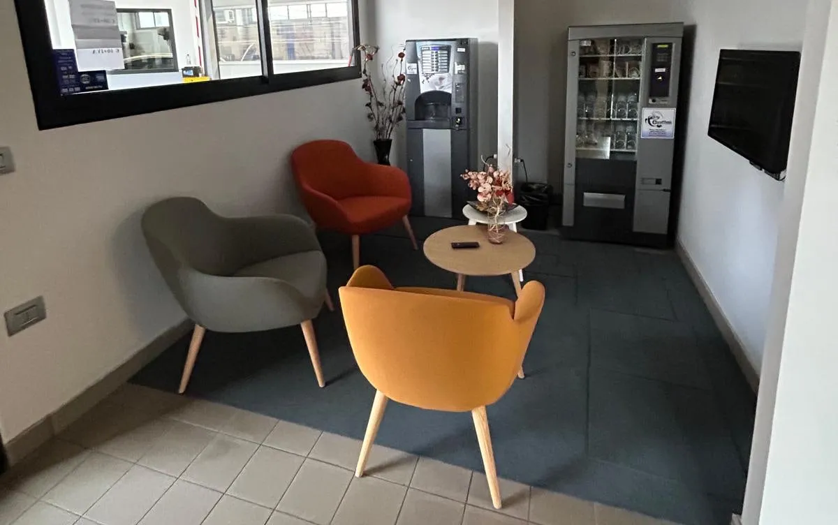La sala d’attesa, con distributore di caffè e televisore
